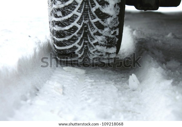 winter tire in snow closeup\
with original pattern of winter tires for advertising banner with\
winter tires or for article about use of winter tires on snow and\
ice