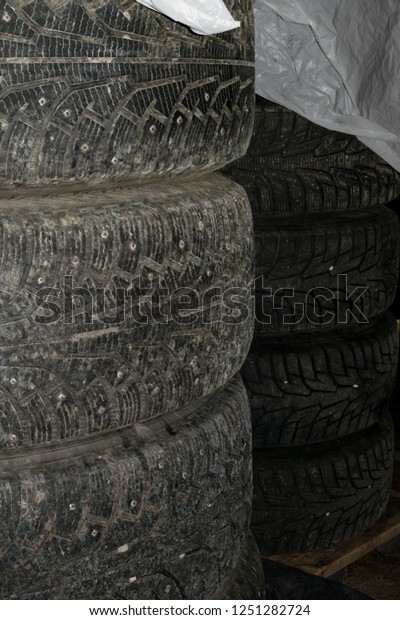 winter tires set with spikes covered plastic\
wrap, storage