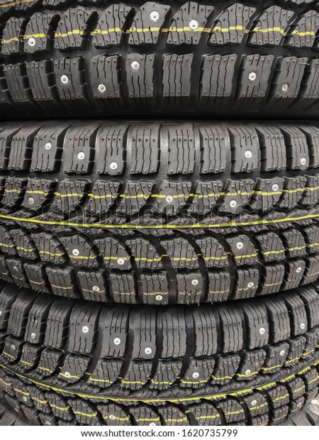 Winter tires. Texture with winter wheels closeup\
- tread and spikes.