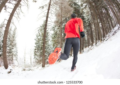 Winter Trail Running: Man Takes A Run On A Snowy Mountain Path In A Pine Woods.