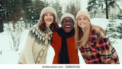 Winter Vacation Together. Three Multiethnic Happy Friends Wave, Smile At Camera At Beautiful Snowy Forest Slow Motion.