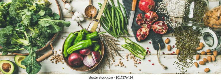 Winter vegetarian, vegan food cooking ingredients. Flat-lay of vegetables, fruit, beans, cereals, kitchen utencil, dried flowers, olive oil over white wooden background, top view. Clean eating food - Shutterstock ID 1017276424