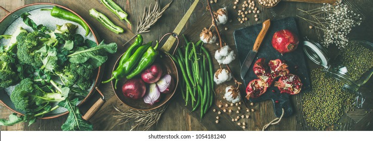 Winter vegetarian, vegan food cooking ingredients. Flat-lay of seasonal vegetables, fruit, beans, cereals, kitchen utencils, dried flowers, olive oil over wooden background, top view, wide composition - Shutterstock ID 1054181240