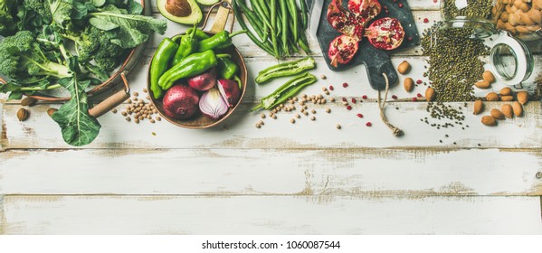 Winter vegetarian, vegan food cooking ingredients. Flat-lay of vegetables, fruit, beans, cereals, kitchen utencil, dried flowers, olive oil over white wooden background, top view, copy space - Shutterstock ID 1060087544