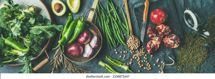 Winter vegetarian, vegan food cooking ingredients. Flat-lay of seasonal vegetables, fruit, beans, cereals, kitchen utencils, dried flowers, olive oil over wooden background, top view, wide composition - Shutterstock ID 1106871647