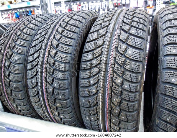 Winter vehicle tires stacked up\
for sale in the chain hypermarket. New studded tyres for\
sale