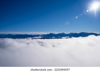 Winter viev from the top of Pyramidenkogel tower in Austria on the high Karawanken mountains  in Slovenia, above the clouds, during sunny day. 