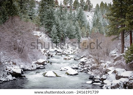 Winter view of the Deschutes River from the South Canyon Reach of Deschutes River Trail, hiking and running trail,  in Bend, Oregon in winter with fresh powder snow 