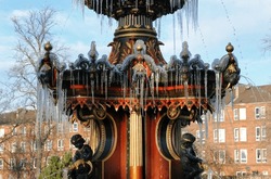 Winter View Of Frozen Water On Ornate Victorian Cast Iron Fountain In Public Park In Close Up 