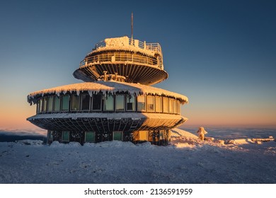 Winter view of the Meteorological Observatory on Śnieżka in the Karkonosze Mountains. The beautiful light of the rising sun creates an amazing atmosphere