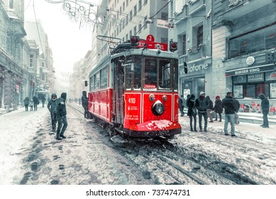 Winter View Of Nostalgic Red Tram And People In Daily Life While Snowing At Popular Istiklal Street Of Beyoglu,Istanbul,Turkey.07 January 2017