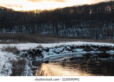 Winter View On Frozen River Shore. Siverskyi Donets River Covered In Snow In Ukraine. Sunset Sun In Clouds Above Woody Hill