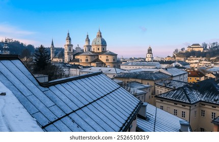 Winter view of Salzburg's iconic architecture under a clear blue sky with snow-covered rooftops and historic churches - Powered by Shutterstock