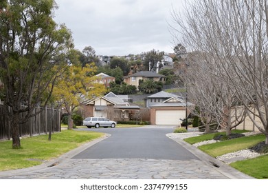 Winter view of a suburban road leads to a court, an enclosed road or cul-de-sac that typically forms a circular shape with no outlet on one end, in an Australian neighbourhood with residential houses