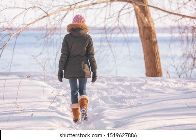 Winter Walk Woman Walking Out On Nature River Background In Cold Outdoor Nature River Outside Wearing Wool Hat, Scarf And Fur Jacket Outerwear Enjoying Outdoors.