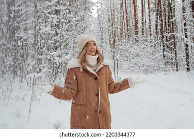 Winter walk, a young beautiful blonde in winter clothes walking in a snowy forest, a beautiful frosty day