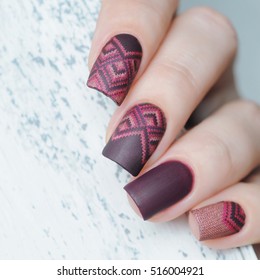 winter warm knitted manicure on wooden background