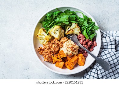 Winter Warm Vegan Buddha Bowl With Beans, Baked Vegetables, Tofu, Hummus And Beans.