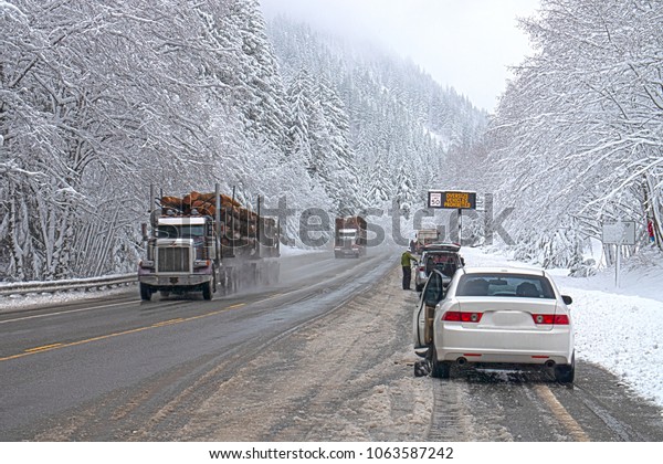 Winter Weather Harsh Road Conditions\
People Putting Chains on Vehicles Snowy Mountain\
Pass
