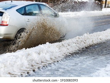 In Winter, A White Car Drives Through A Water Score And A Splash Of Points