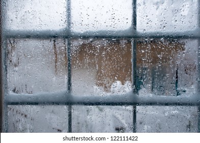 Winter window, drops of water and snowflakes on a window pane.
