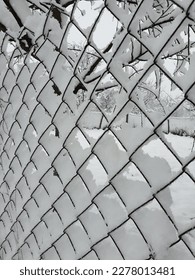 winter - wire-mesh fence covered by white snow - Shutterstock ID 2278013481
