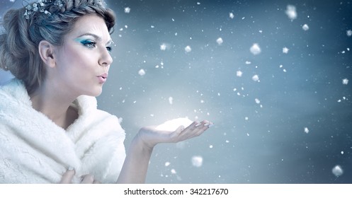 Winter woman  blowing snow over blue background - snow queen
