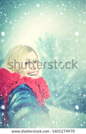 Winter woman. Girl playing with snow throwing a ball in winter holidays. Portrait of a happy woman in the winter. Cheerful girl outdoors