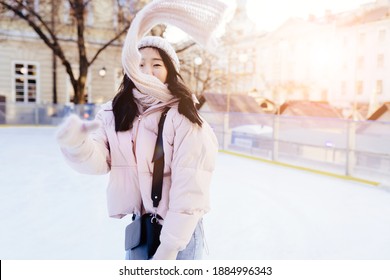 Winter Woman Happy Outside In Snow Smiling Joyful On Snowing Winter Day. Cute Beautiful Mixed Race Caucasian Asian Girl With Flying Scarf To Skate On The Rink Cheerful And Excited Outdoors.