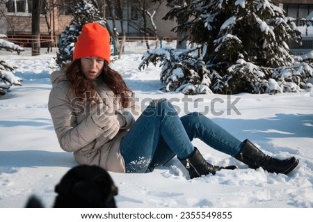 winter woman in orange warm hat sit in snow wintertime. winter fashion of woman in warm hat with wintertime snow.