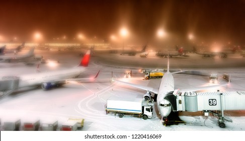 Winter Wonderland Airport Overview At Night With Snow Aircraft Apron Passenger Planes Parked To Terminal Building Gate Aerial Panoramic View Air Travel Aviation Transportation Creative Blur Background