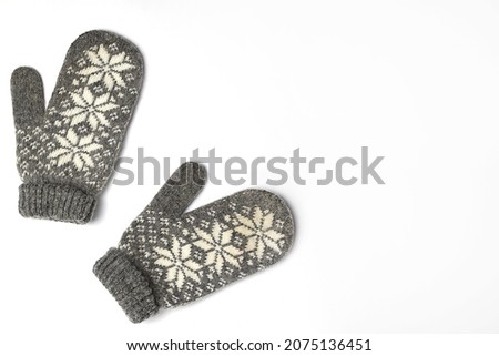 Winter woolen mittens with a pattern isolated on a white background. Winter accessory. Flat lay, top view.