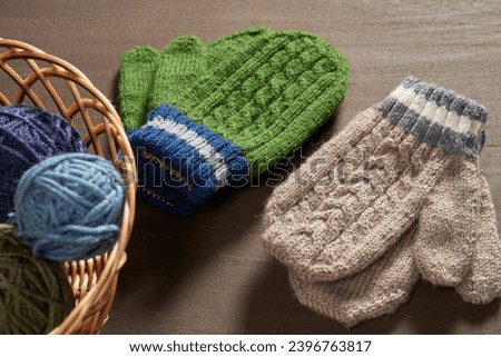 Winter woolen mittens with a pattern isolated on a wooden background. Winter accessory.