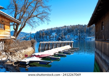 Winterlandscape at a lake with mirroring, reflections and blue sky in Bavaria, central Europe