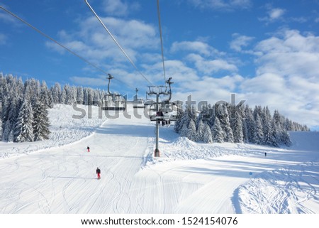 Wintersports fans riding the ski lift to empty pastes in the Alpine ski resort of Avoriaz.