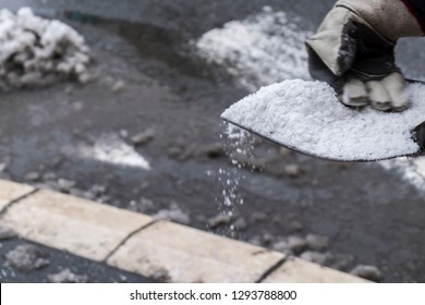 Winter.Worker Spreading Salt On Icy Sidewalk