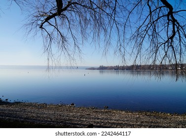 wintery peaceful scenery with lake Ammersee in Herrsching in Bavaria (Germany)                               