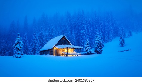 A wintery scene in the heart of the woods with a solitary wooden cottage and snow-draped pine trees on a mountain glade. Christmas postcard. Snowy mountains forest - Powered by Shutterstock