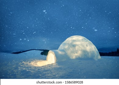 Wintry Scene With Snowy Igloo And Milky Way In Night Sky. Fantastic Winter Landscape Glowing By Star Light. Santa House From Snow, Ideal New Year And Christmas Background