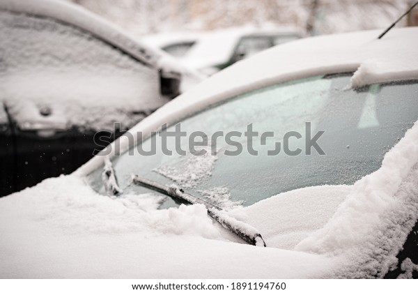 Wiper blades clean the icy\
windshield of the car from snow - winter, snowstorm, icing vehicle\
after snowfall, safe winter driving, preparation for the\
trip