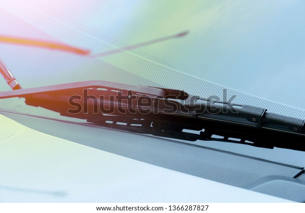 Wiper blades on the windshield With shadows,\
guards and orange light.