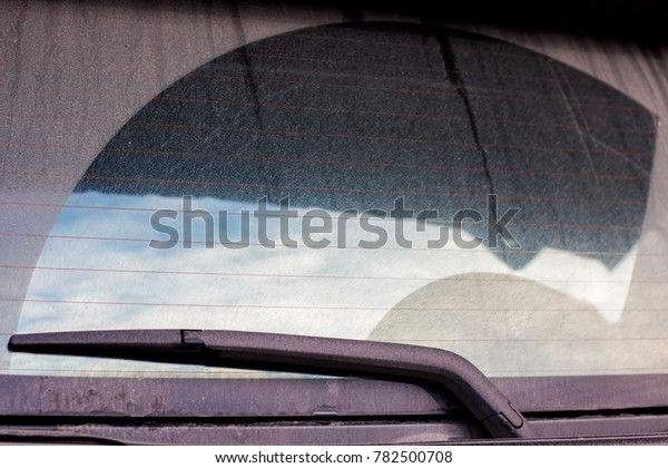wiper clean back car window . the dust\
is dirty . blue beautiful sky and cloud in shadow\
.