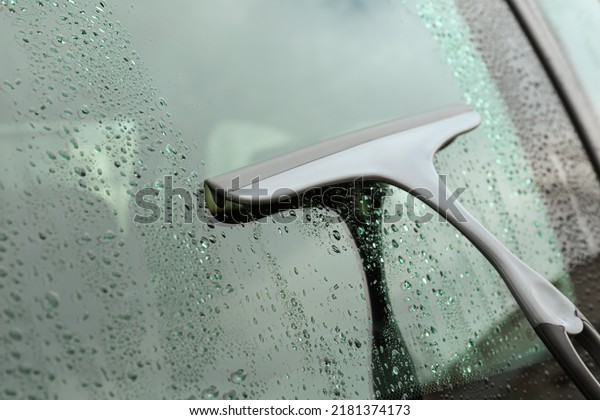 Wiping car
window with drying blade outdoors,
closeup