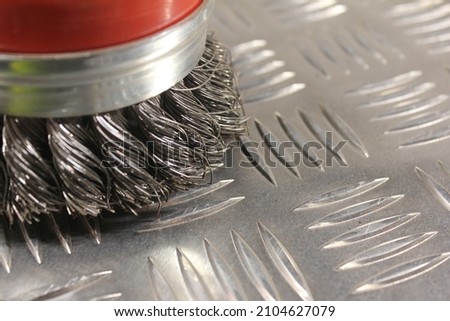 Wire brush on a sheet of aluminium diamond plate