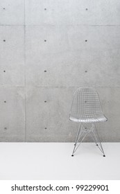 wire chair and concrete wall