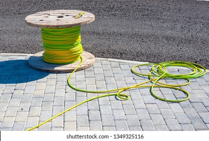 wire electric cable with wooden coil of electric cable waiting to be slipped into the conduit
