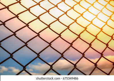 Wire fence or metal net on sunset background, rainbow colorful sky, pastel and vintage style - Powered by Shutterstock