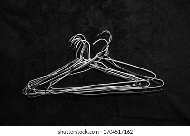 Wire Hangers Stacked On Dark Cloth