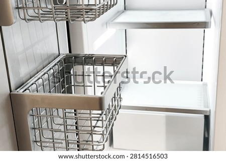 Wire storage baskets hang on a tiled wall with shelves.