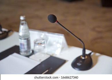Wired microphone set up on the front of conference room close up with blurred background. Wired microphone close up with copy space . Close up of microphone in concert hall or conference room .